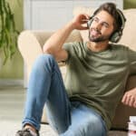 Young man listening to a Spanish audiobook at home