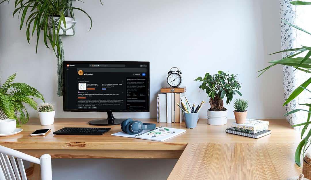 Desk in a sunny room at home with the subreddit r/Spanish on the monitor, illustrating the blog topic Learn Spanish with Reddit