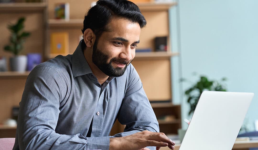 Adult man using a laptop to learn Spanish, illustrating the blog topic of Free Resources for Learning Spanish
