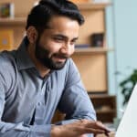 Adult man using a laptop to learn Spanish, illustrating the blog topic of Free Resources for Learning Spanish