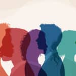 Group of multicolor silhouettes of people of different ethnicities and cultures overlapping with varying opacities, on an abstract background, illustrating the blog topic "How Cultural Immersion Helps You Learn a New Language Faster"